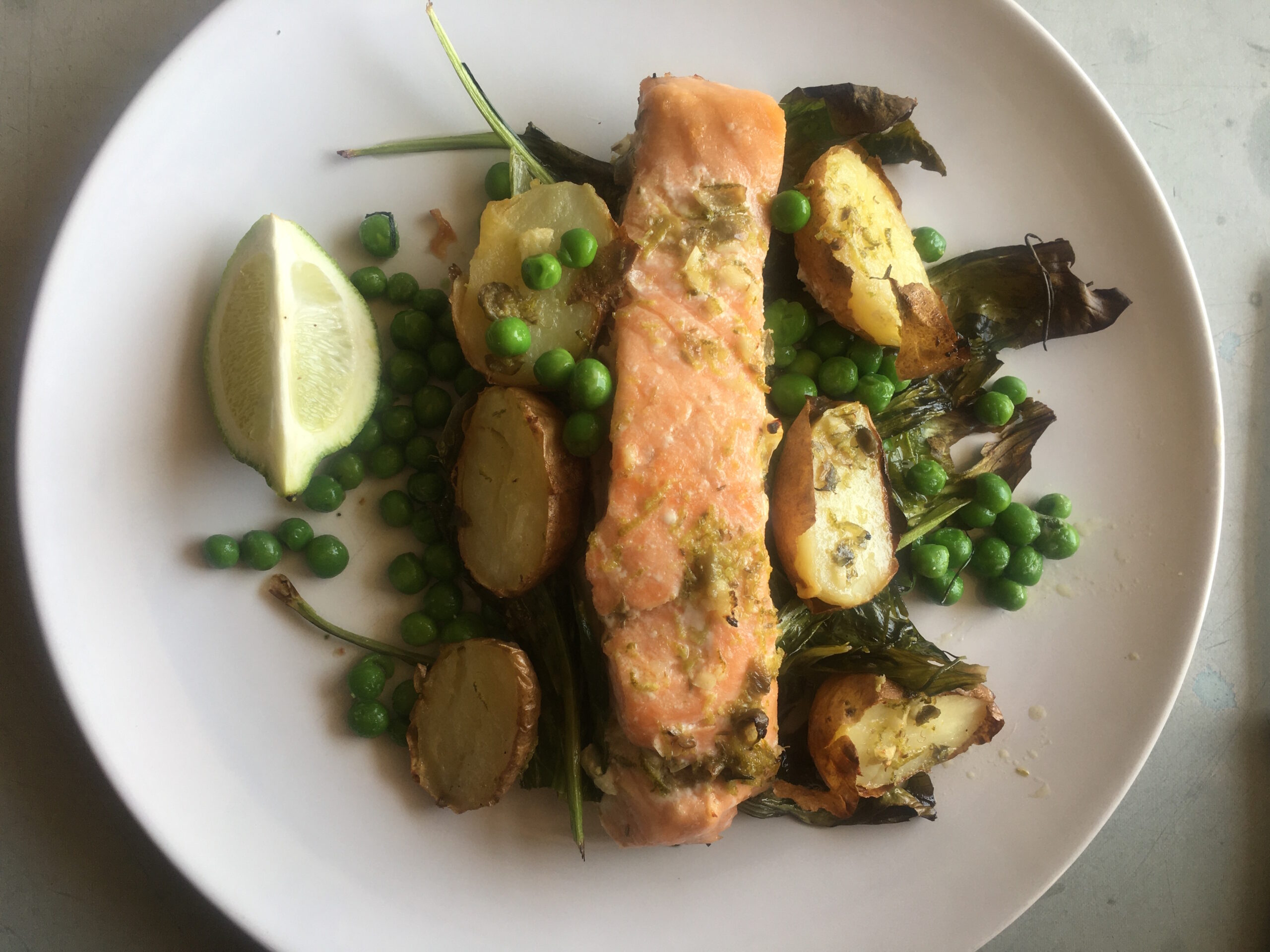 A very delicious baked fish with potatoes, peas, spinach
